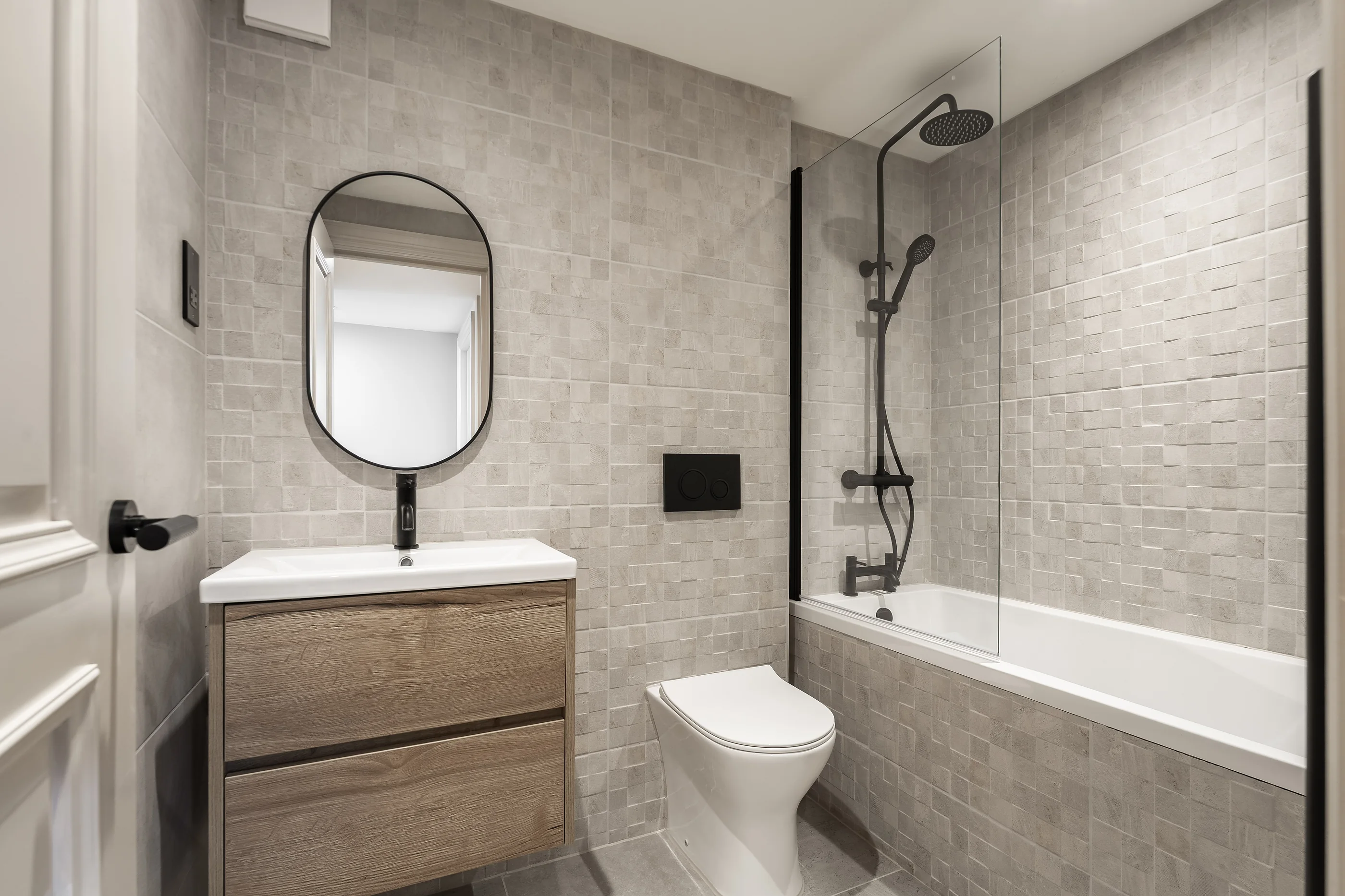 Bathroom with mosaic tiling, oak vanity and black fittings