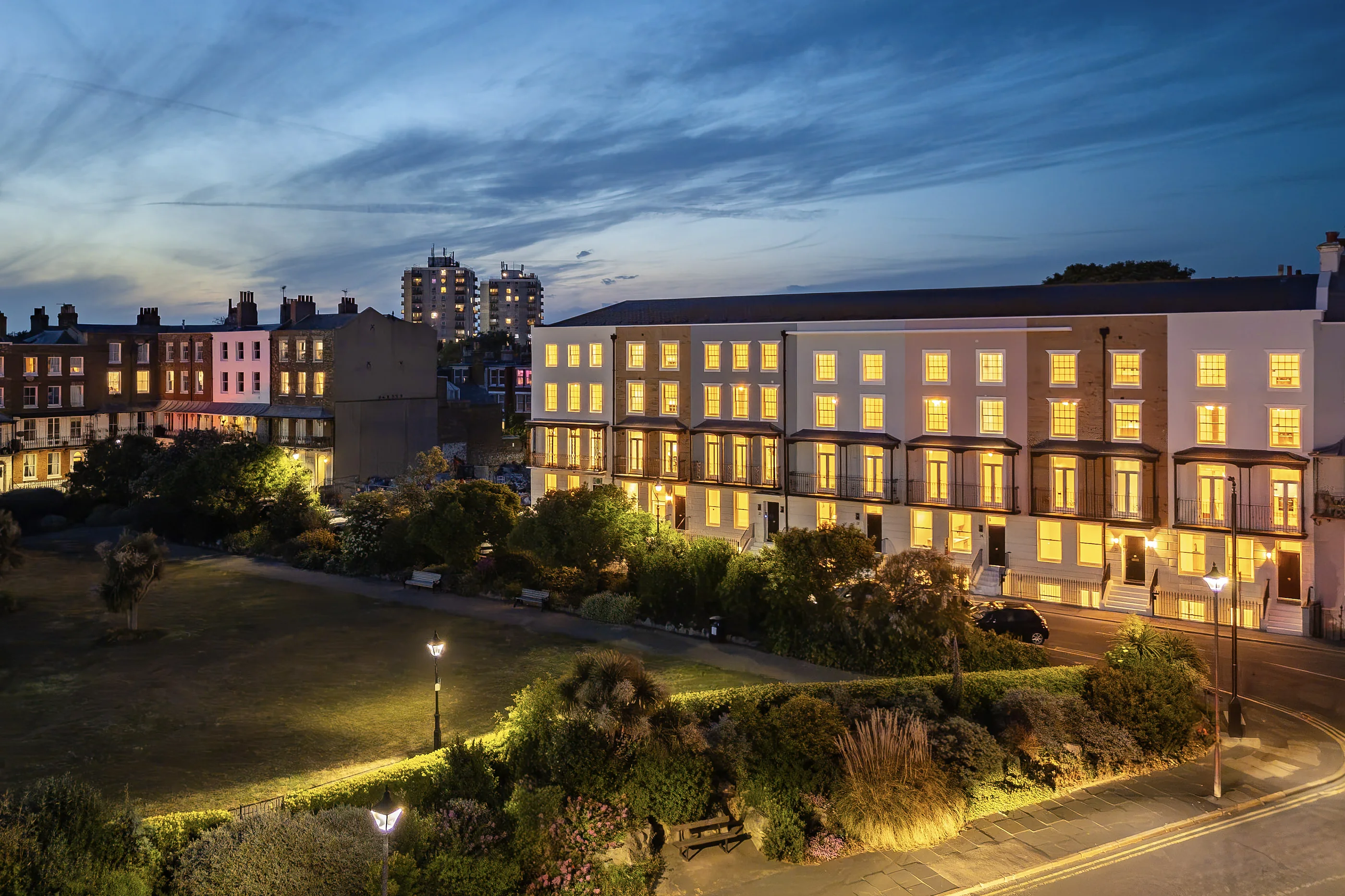 Albion Place lit at dusk, seen across The Green